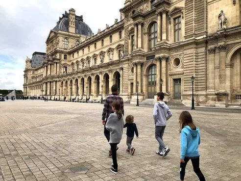 Family walking through Louvre courtyard